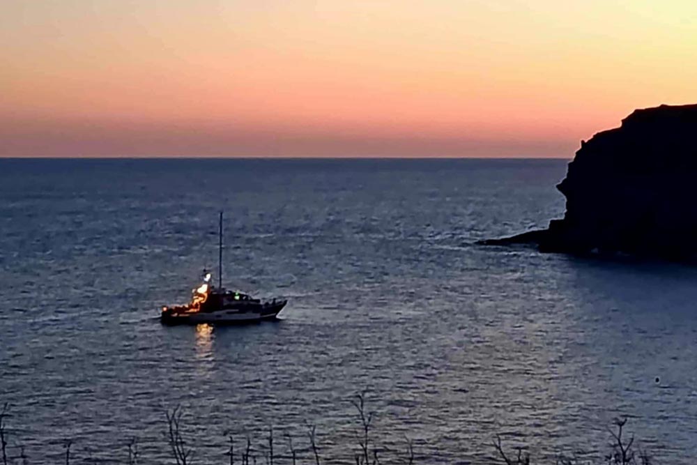 Le canot à couple du voilier, vu de la côte