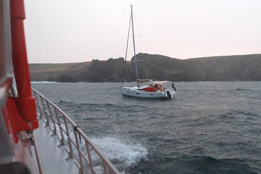 Le voilier au mouillage, à l'arrivée du canot